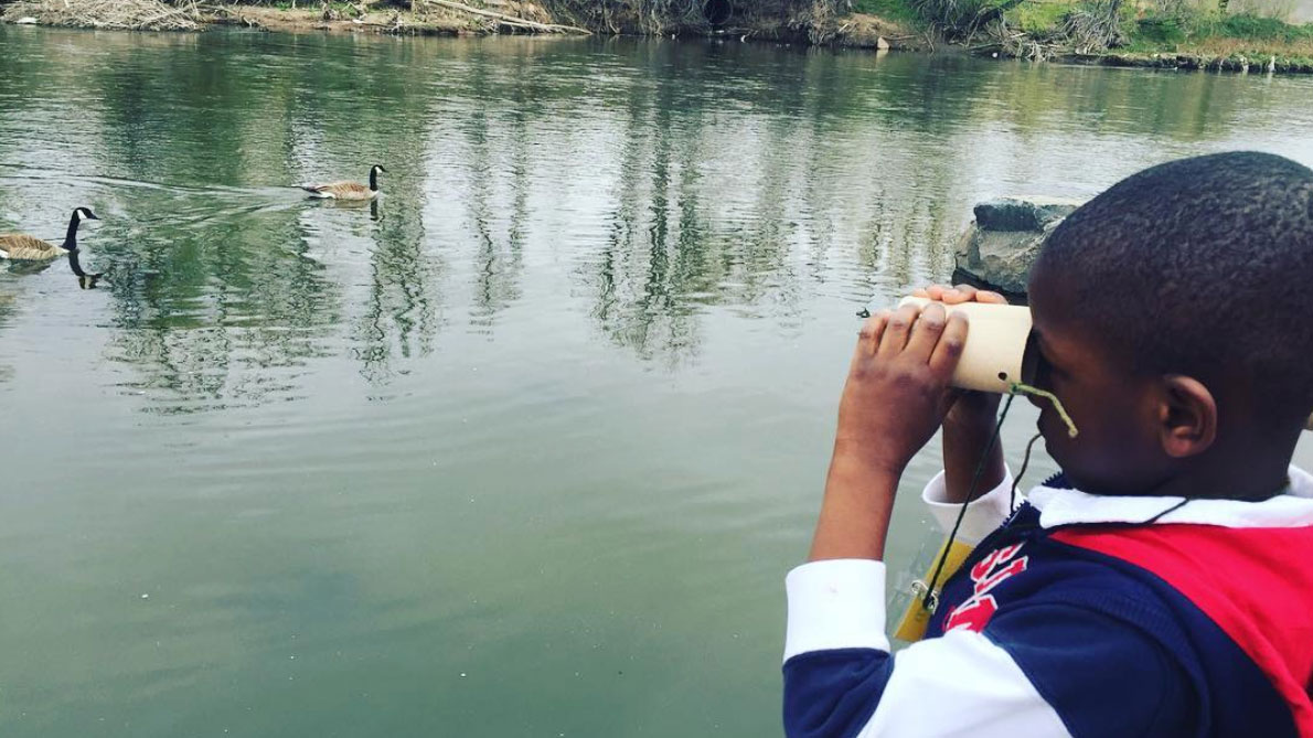 SPREE Student focuses his attention on ducks along the South Platte River through homemade binoculars.