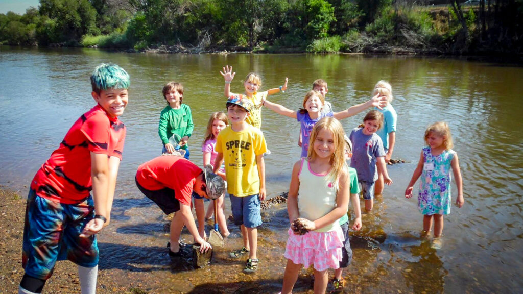 Happy campers at SPREE Summer Camp wade in the South Platte River