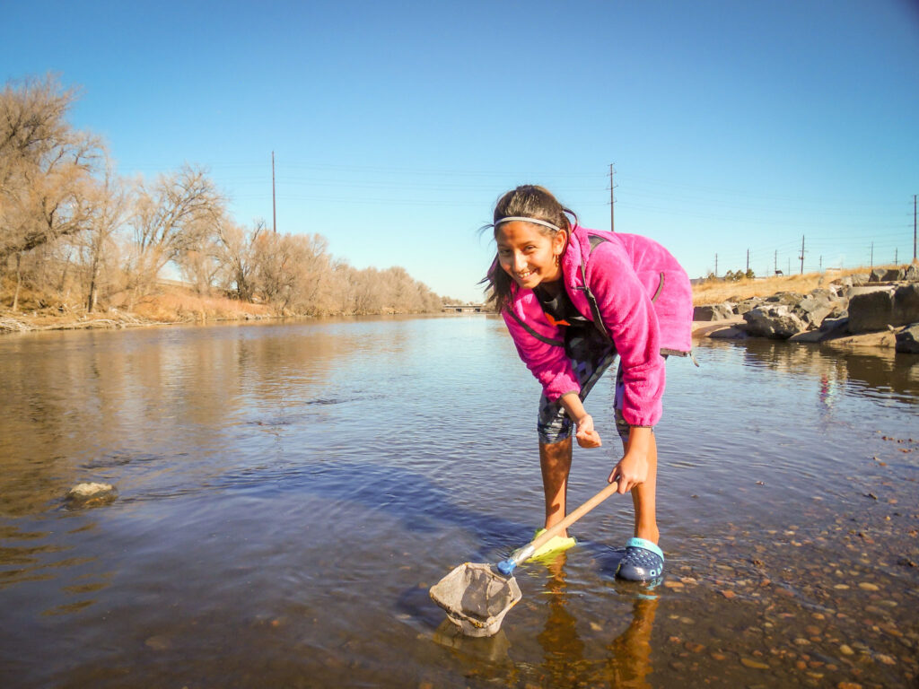 SPREE LIT Camper scoops up a sample from the South Platte River