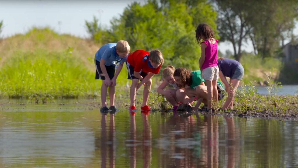 SPREE Summer Camp Staff explores the South Platte River ecosystem with children.