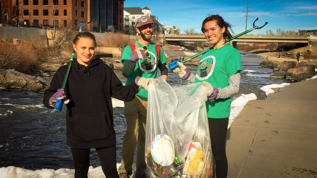 River Rangers collect a bag filled with litter along the South Platte River