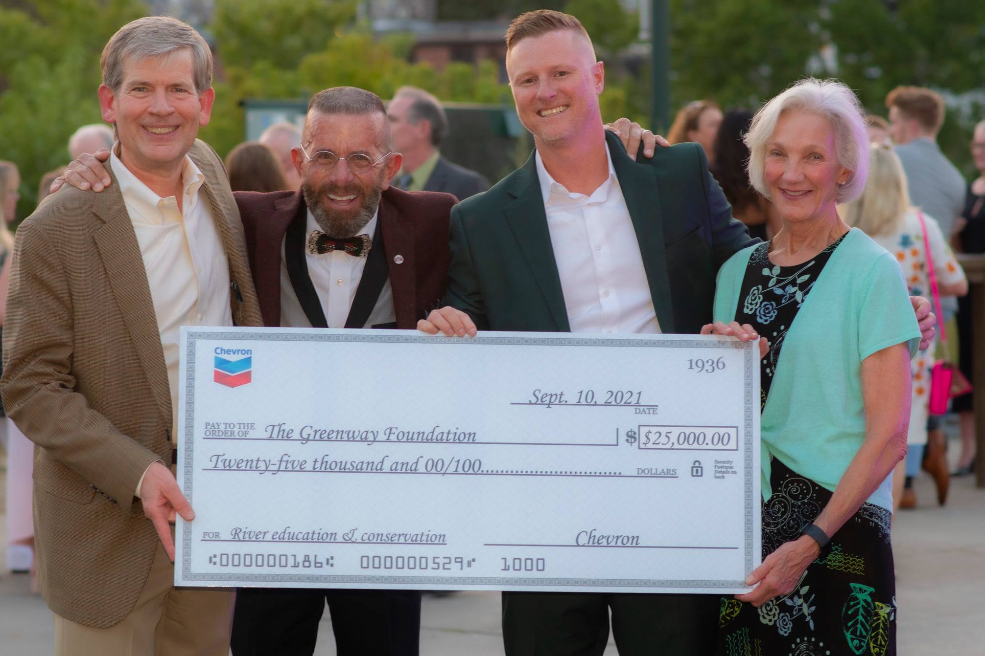 Jeff Shoemaker and Ryan Aids from The Greenway Foundation accept a donation from Chevron.