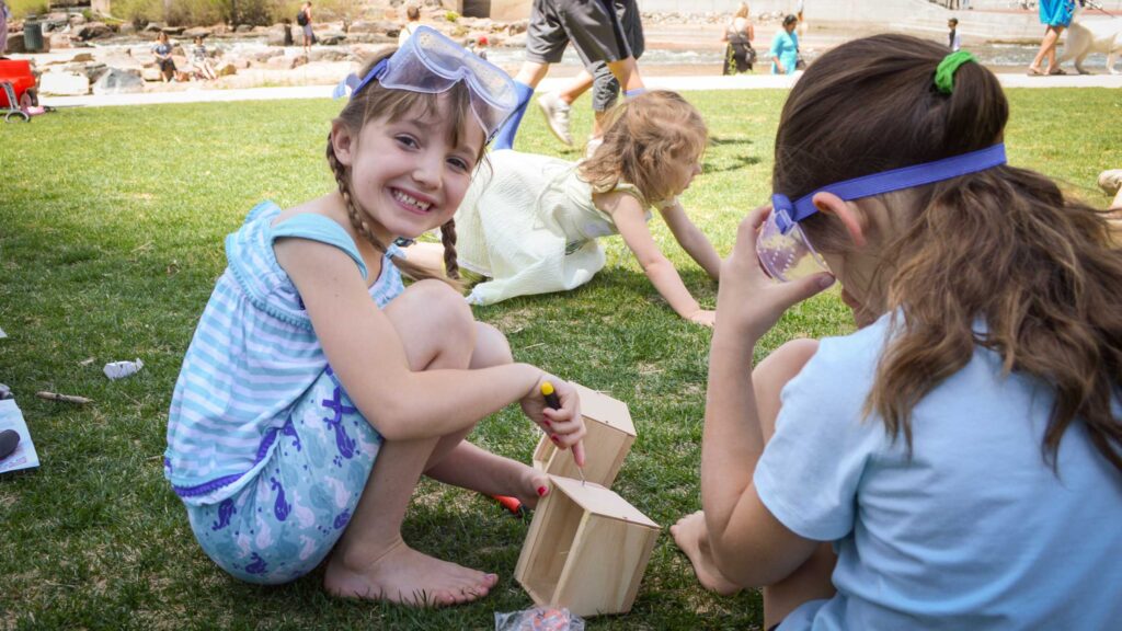 A child begins constructing a bird house at Art on The River