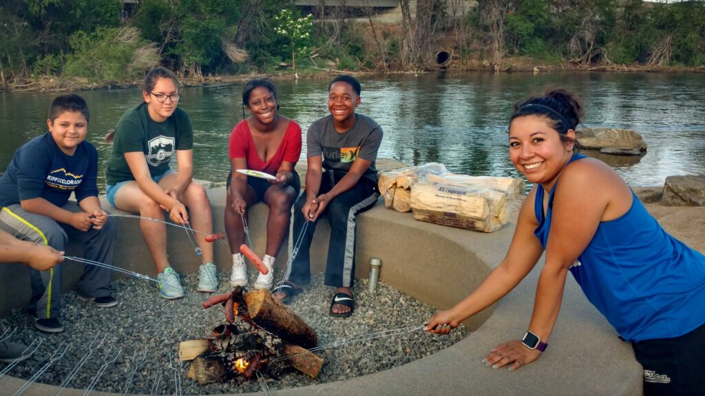SPREE Families roast marshmallows along the South Platte River at a Campout