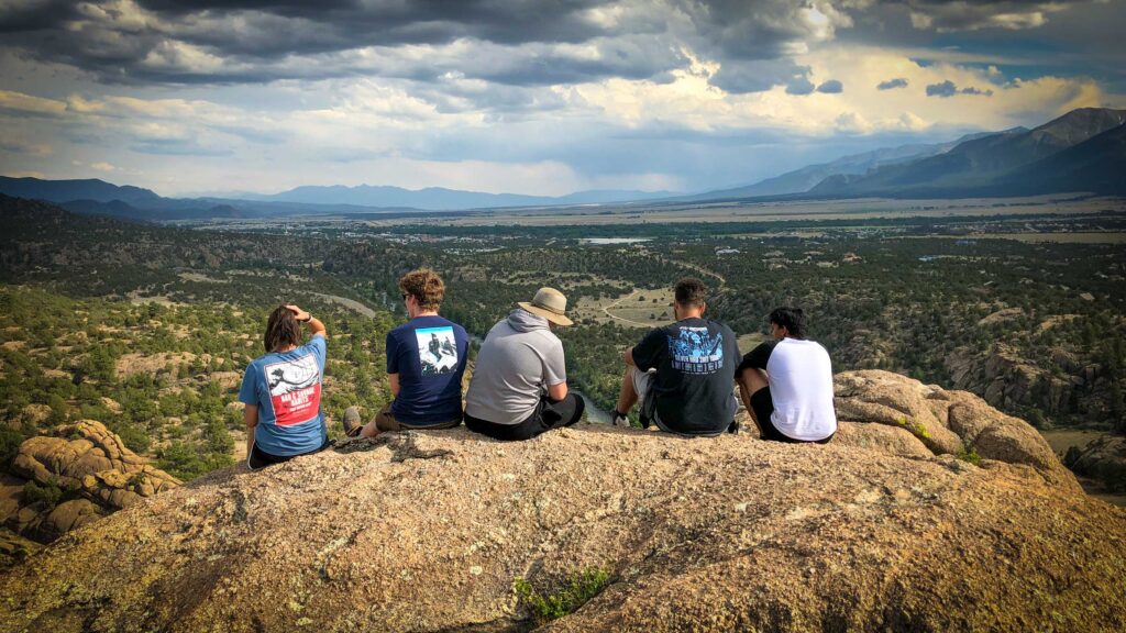 Greenway Leadership Corps members sit on a hill after a hike.