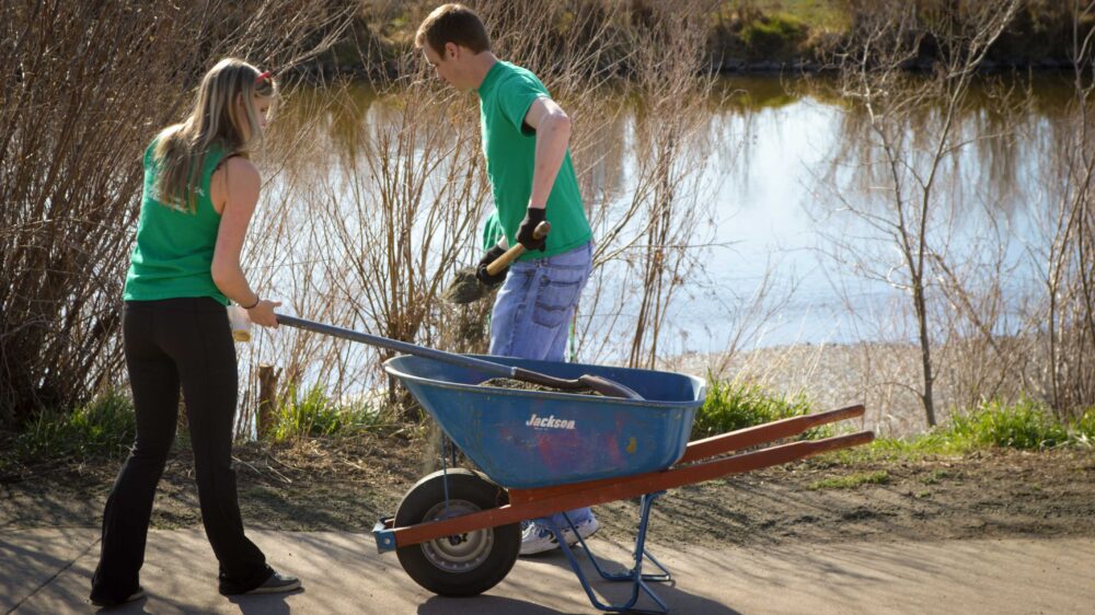 Volunteers at Fall Stewardship Day use mulch to protect plants along the South Platte River