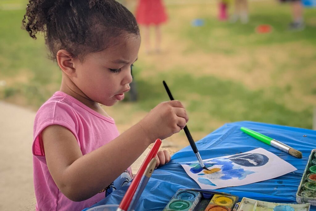 Child paints a river scene a SPREE family event.